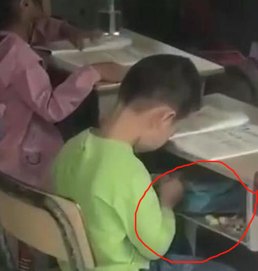 小学生上课不认真,低头只顾拨弄课桌抽屉,老师过来后一下就愣了