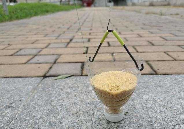 5,如图4所示的安装方式,将酒米导入自制的打窝器中,拉紧带鱼钩的