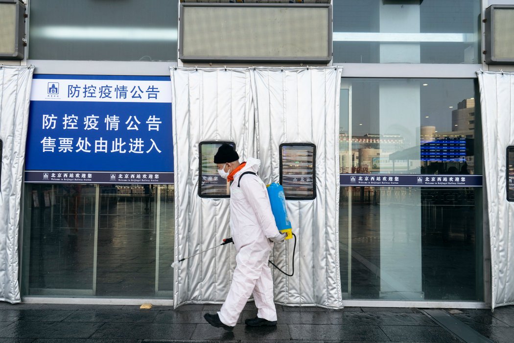 北京西站入口,工作人员正在喷洒消毒剂。