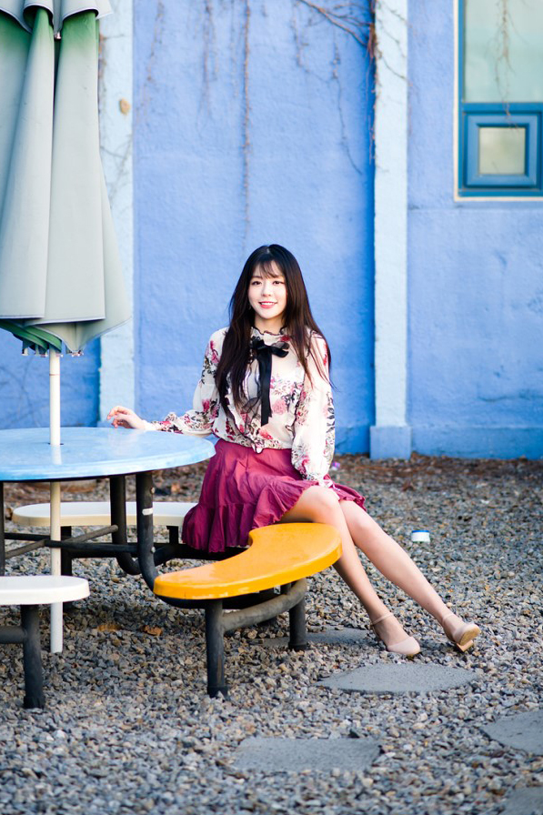 休闲椅子上一个穿雪纺衫和百褶裙的优雅美女