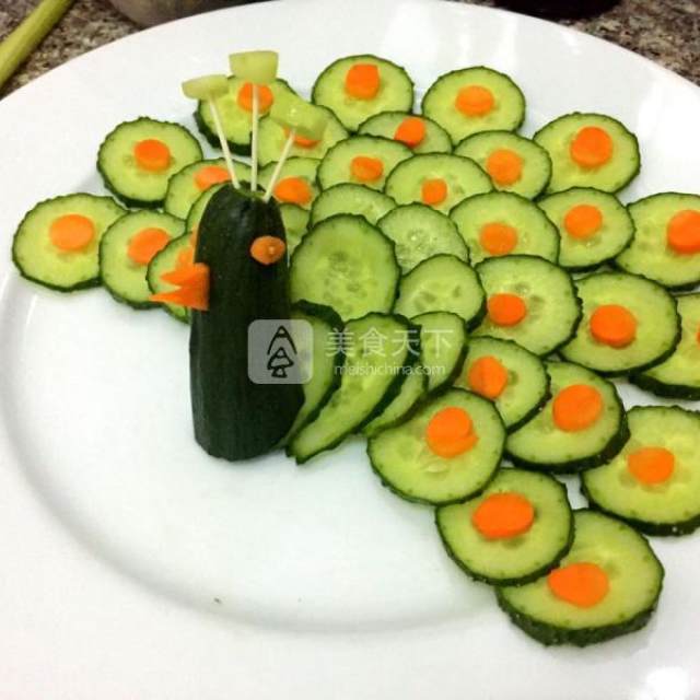 第6步,胡萝卜做出眼睛和嘴巴,用龙须面插好眼睛,嘴巴处挖一个合适的