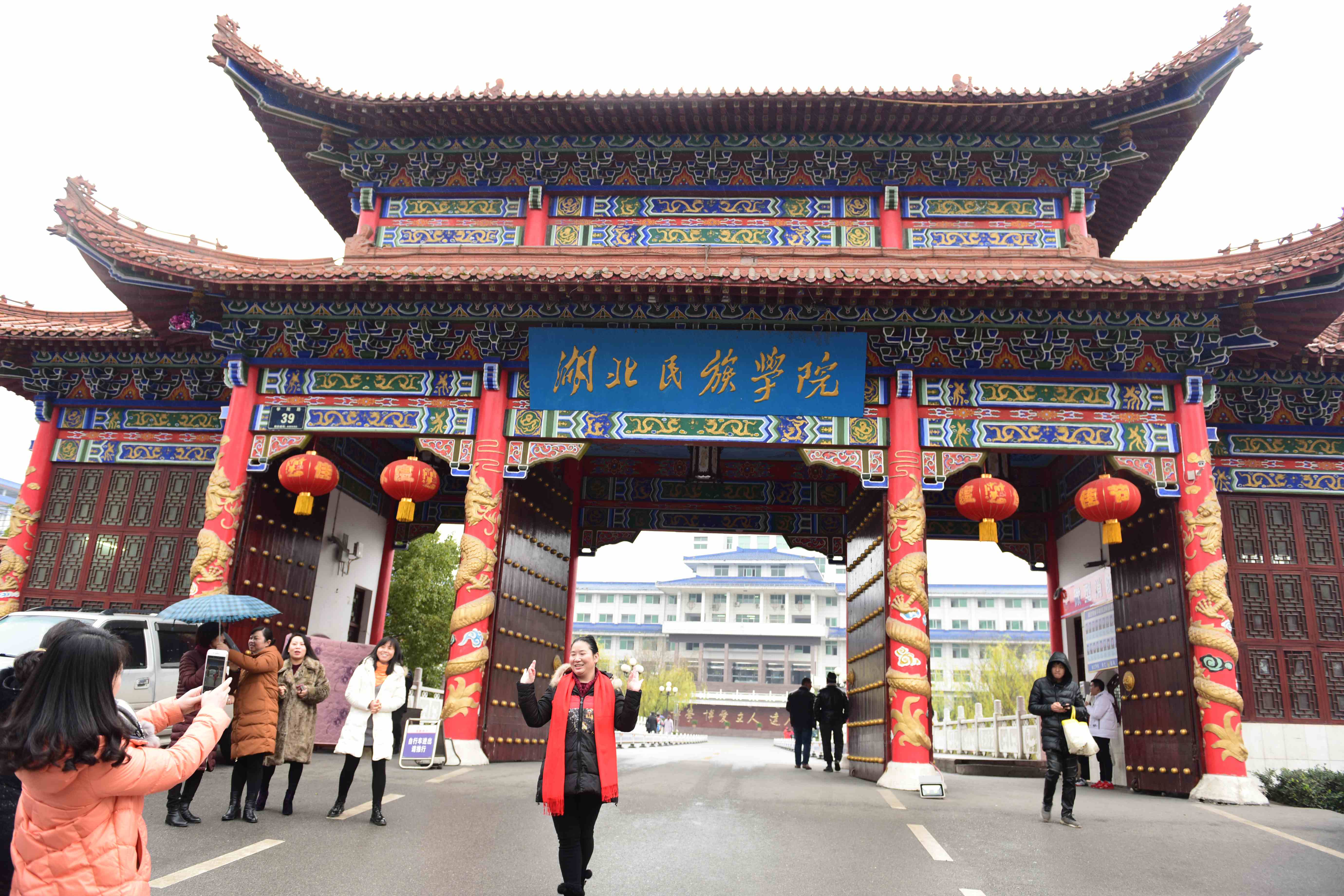 湖北民族学院更名为湖北民族大学,学生在旧牌匾前留影