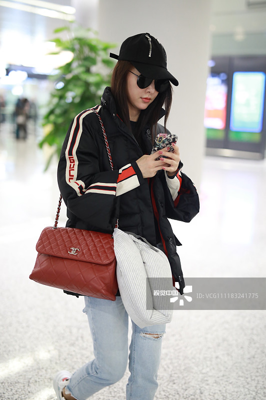 贾青圣诞节穿面包服现身机场 刷手机不忘抬头莞尔一笑