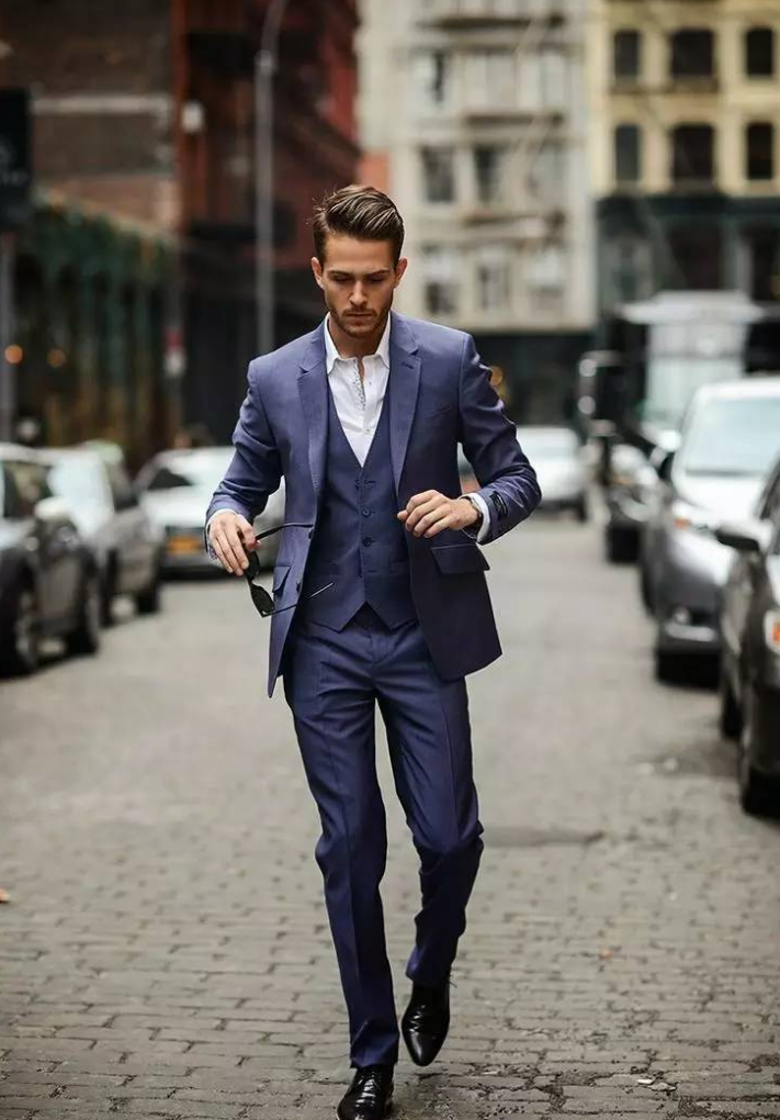 灰蓝色的西装外套搭配同色的西装裤.内搭一件白色衬衣.