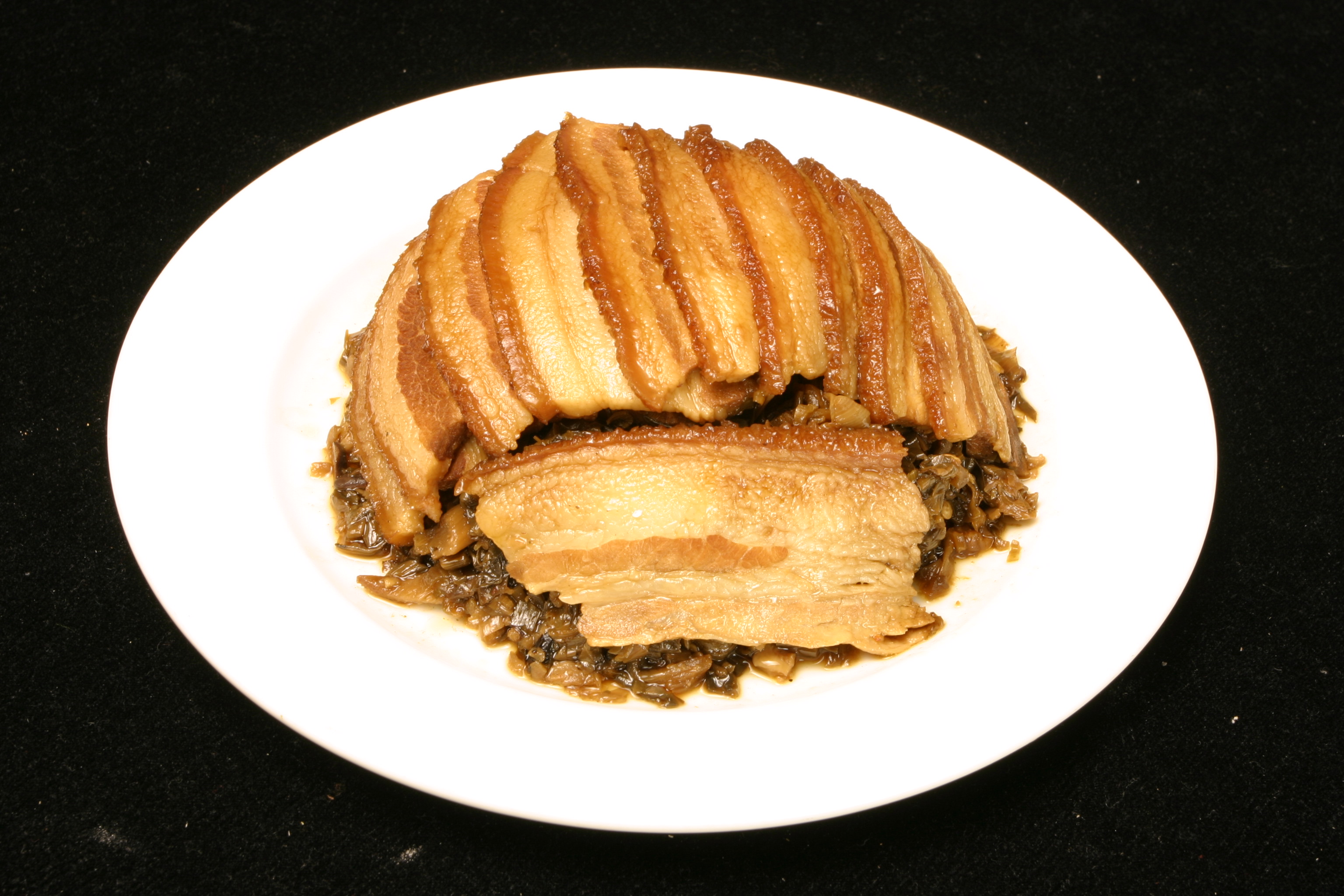 红烧狮子头 主料:梅子肉500克,荸荠200克,香菇6朵;辅料:酱油适量,葱1