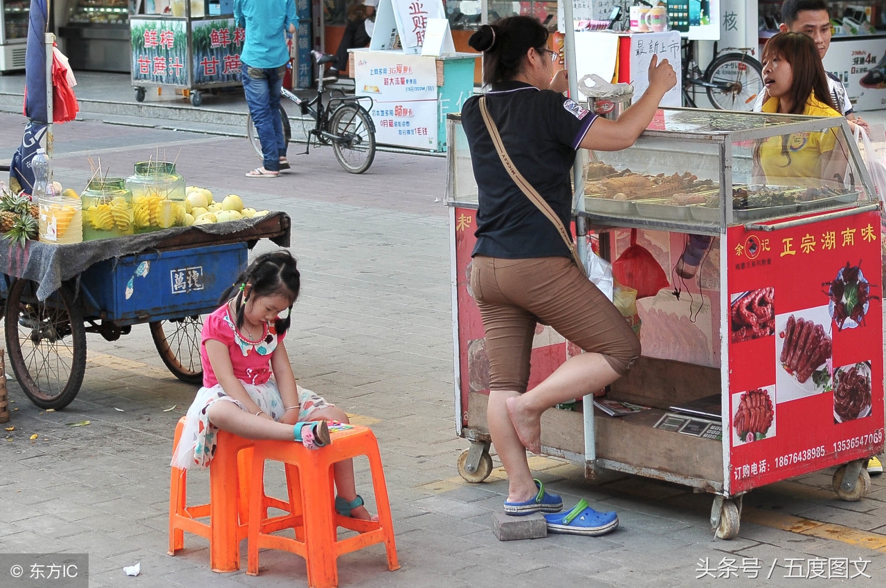 这是一位进城摆摊做缝补的母亲,一架缝纫机加上各种针线布料是她养家