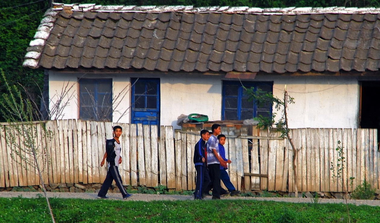 图为鸭绿江边的朝鲜农村场景,房屋都很陈旧,周围都围着篱笆.