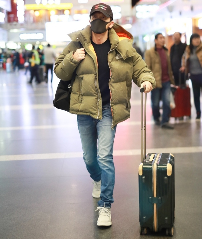 李晨穿厚实羽绒服单手拖箱子不忘与粉丝招手,人气不减