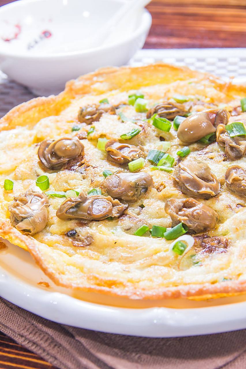 蚵仔煎是一道台湾著名小吃,以新鲜蚵仔和酥脆面糊煎炸而成.