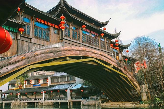 城内斗拱飞檐,车水马龙,宋河两岸翠绿,一架飞桥悬于河上