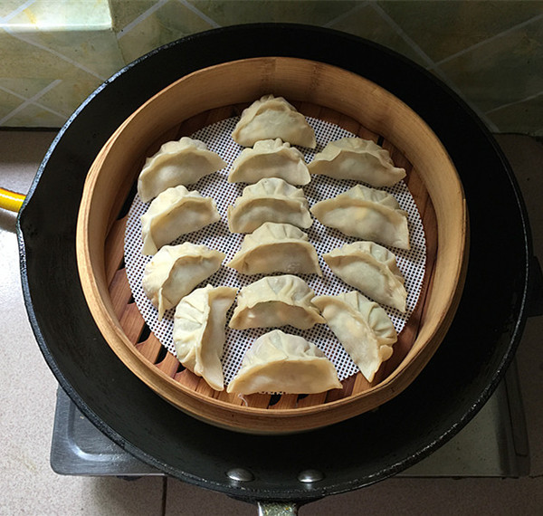 蒸锅底部放硅胶垫,刷薄油后摆上包好的饺子胚锅中烧水,水开后入蒸笼