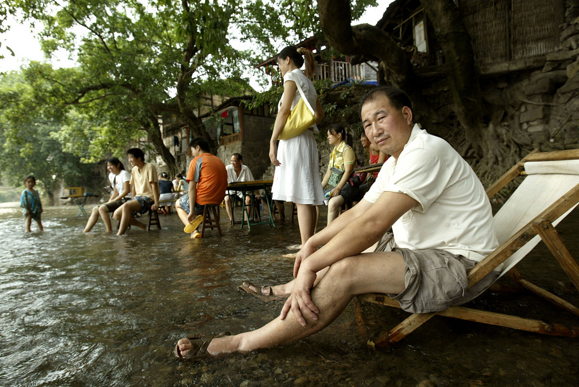 有这么一个地方,夏天非常火爆;一条浅浅的小溪,上面摆满了麻将桌椅