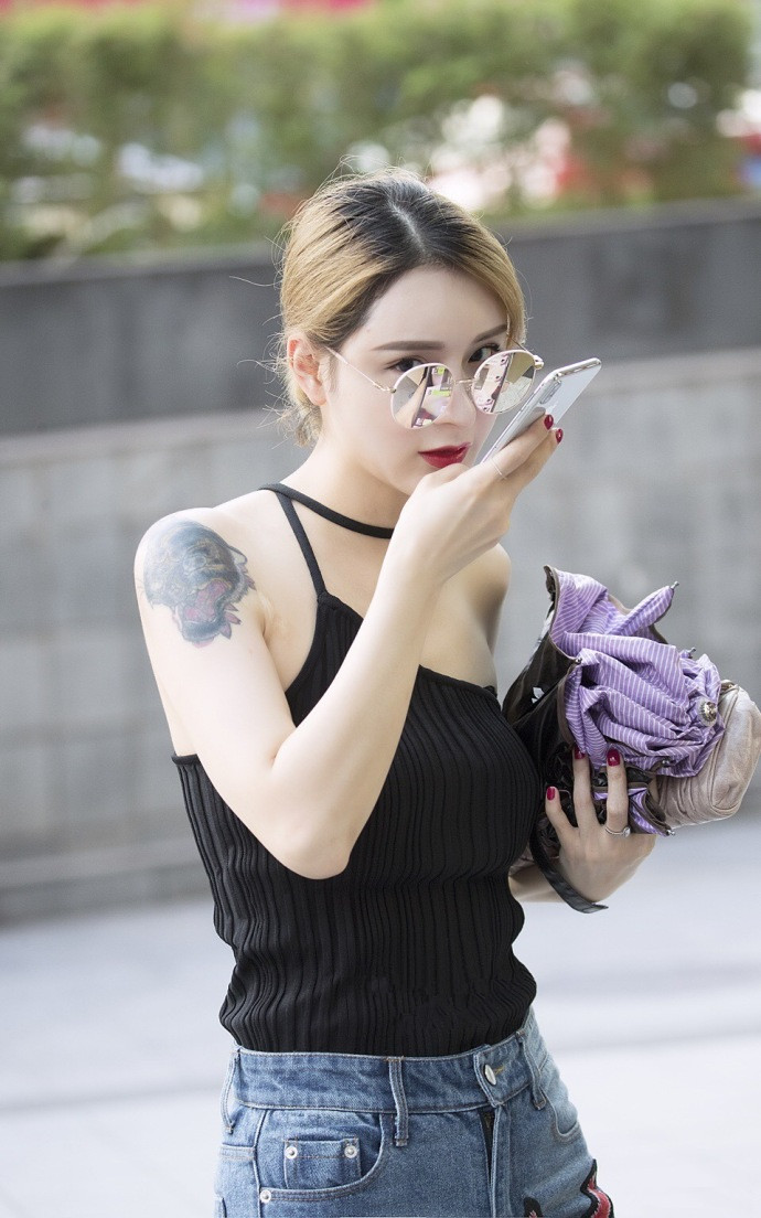 一位眼神深邃的美女,身穿一袭黑衣,搭配一双皮靴,还真有种女神的气质!