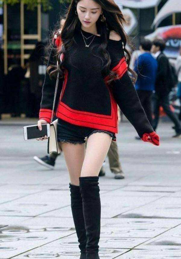 街拍:长发飘飘的美女,黑色短裤搭配黑色长筒靴,女神气质十足