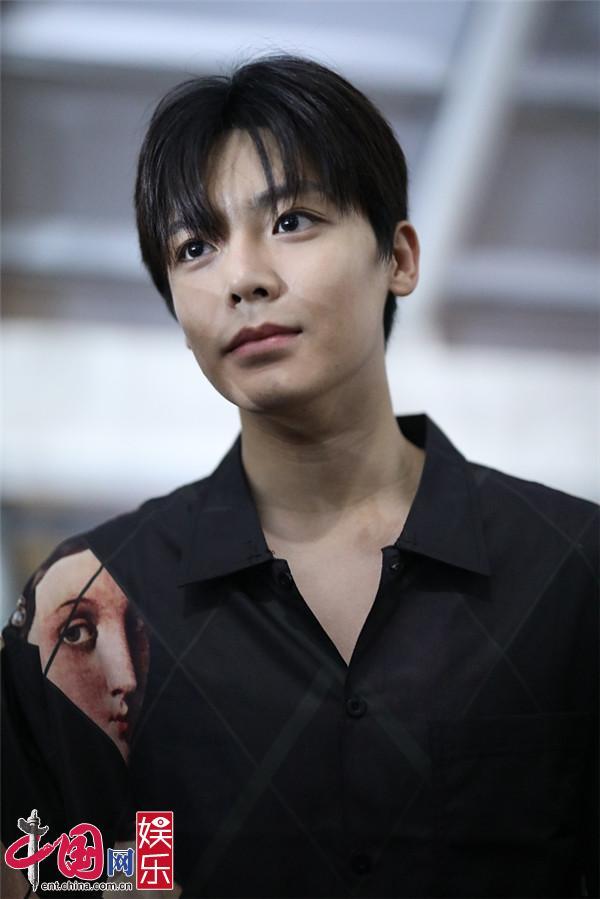 侯明昊穿黑衬衫抿嘴浅笑 侧颜帅气黑发顺毛造型显乖巧