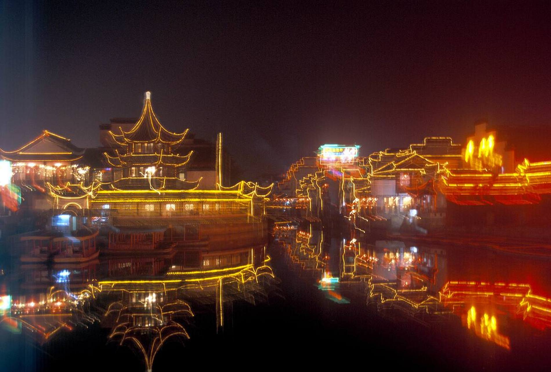 苏州夜晚的船游古运河如诗如画,两岸灯光倒映水中五彩斑斓,古建筑庄重