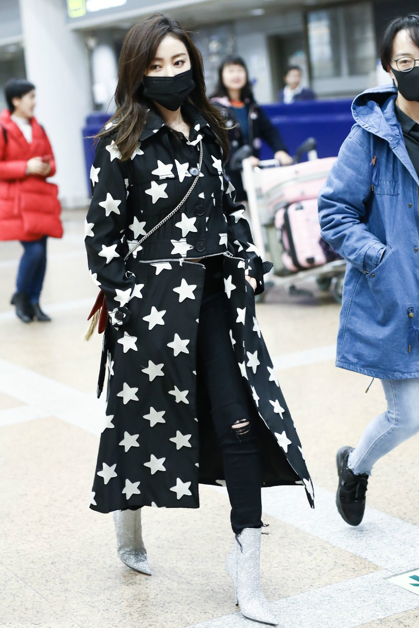 张天爱穿五角星印花图案长款风衣现身机场,戴着黑色口罩遮面