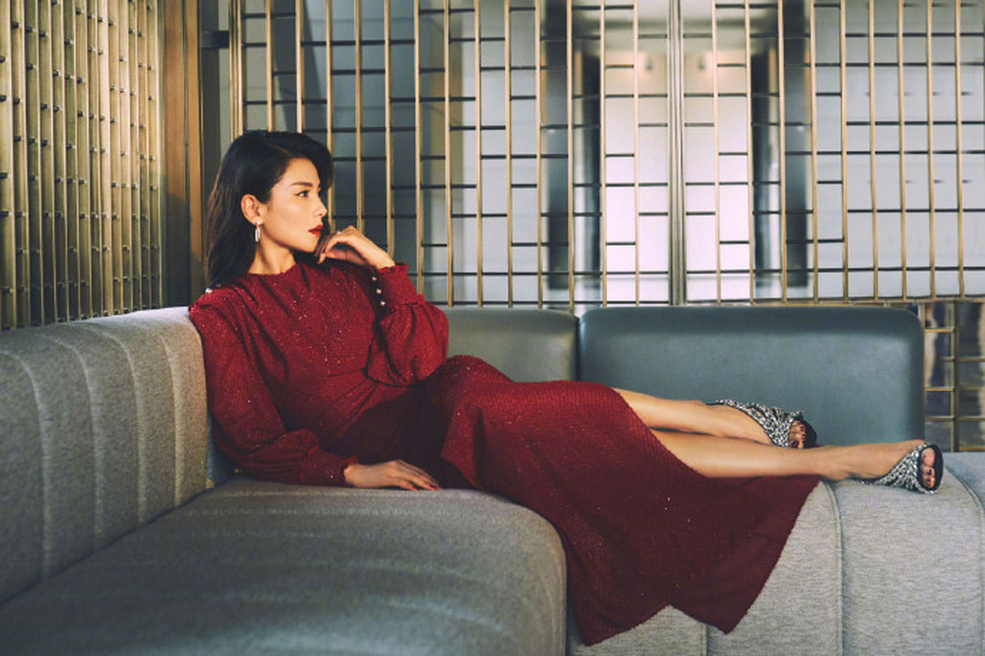 一袭红色亮面开叉长裙温婉优雅,复古风微卷中长发搭配精致眼妆,一抹