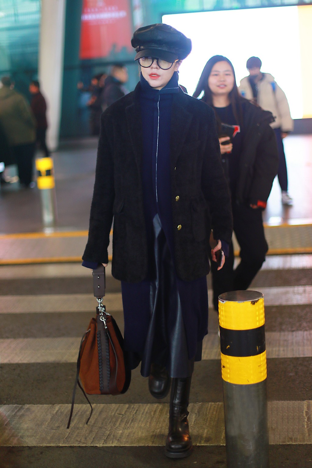 郁可唯现身机场,蓝色长款外套叠穿黑色西装,配报童帽复古又帅气
