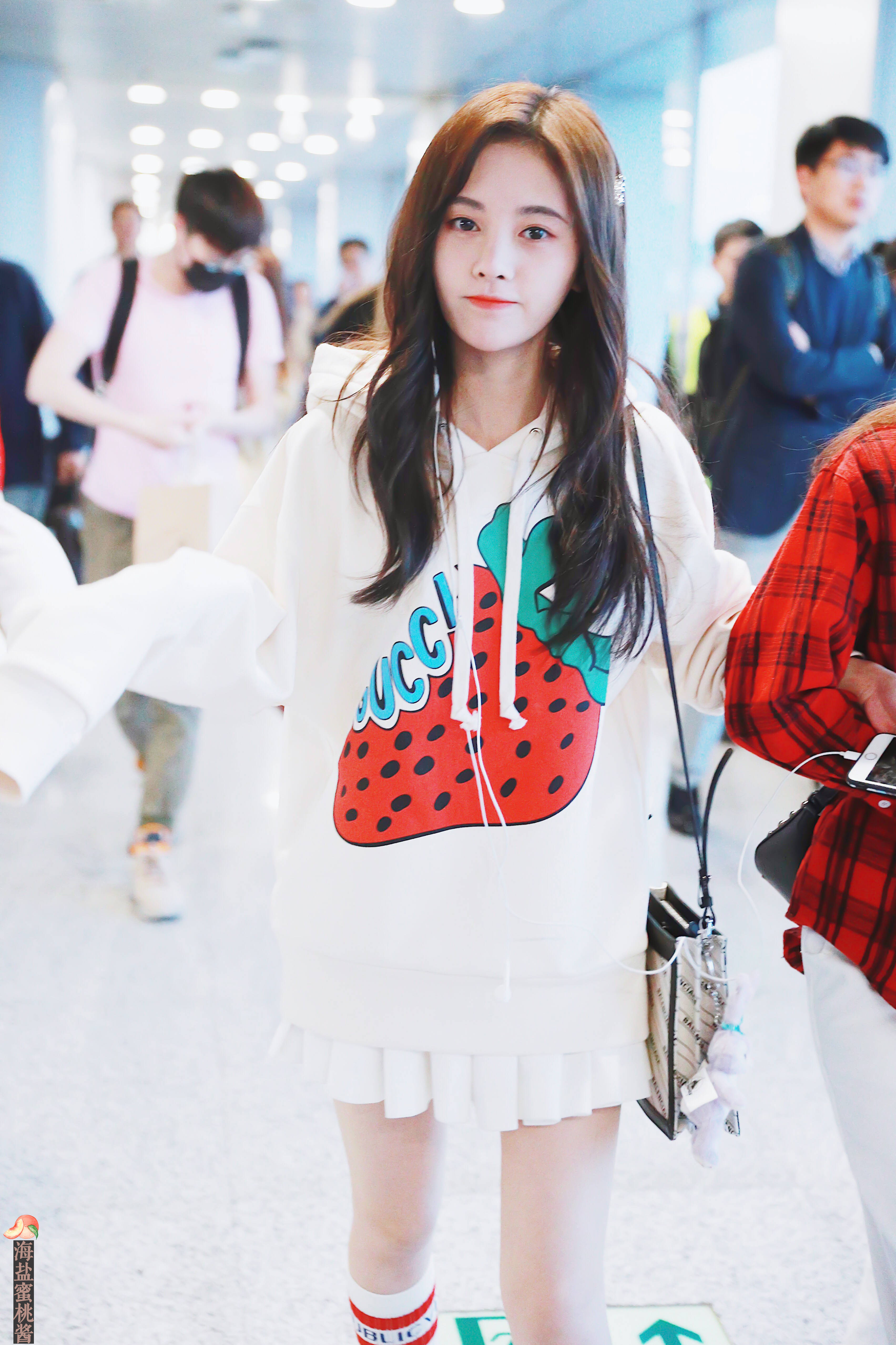 鞠婧祎穿白色卫衣搭配白色百褶短裙现身机场,皮肤白皙面带微笑