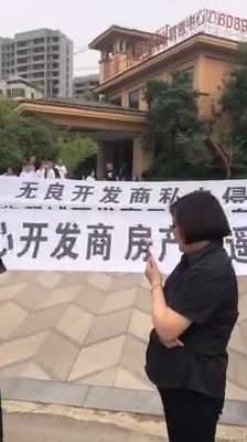 商丘華遠翡翠城的業主在建業.香檳聖園售樓部外拉起橫幅為何事?