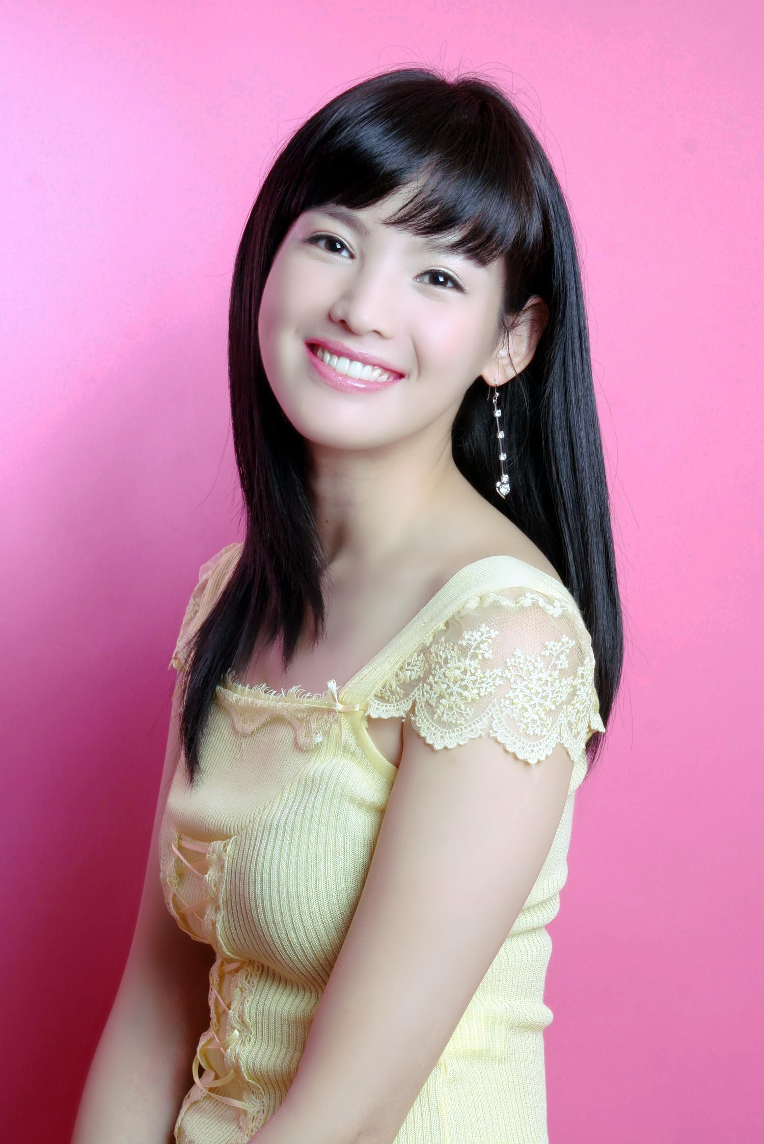 粉红色背景下一个笑容甜美的可爱女子