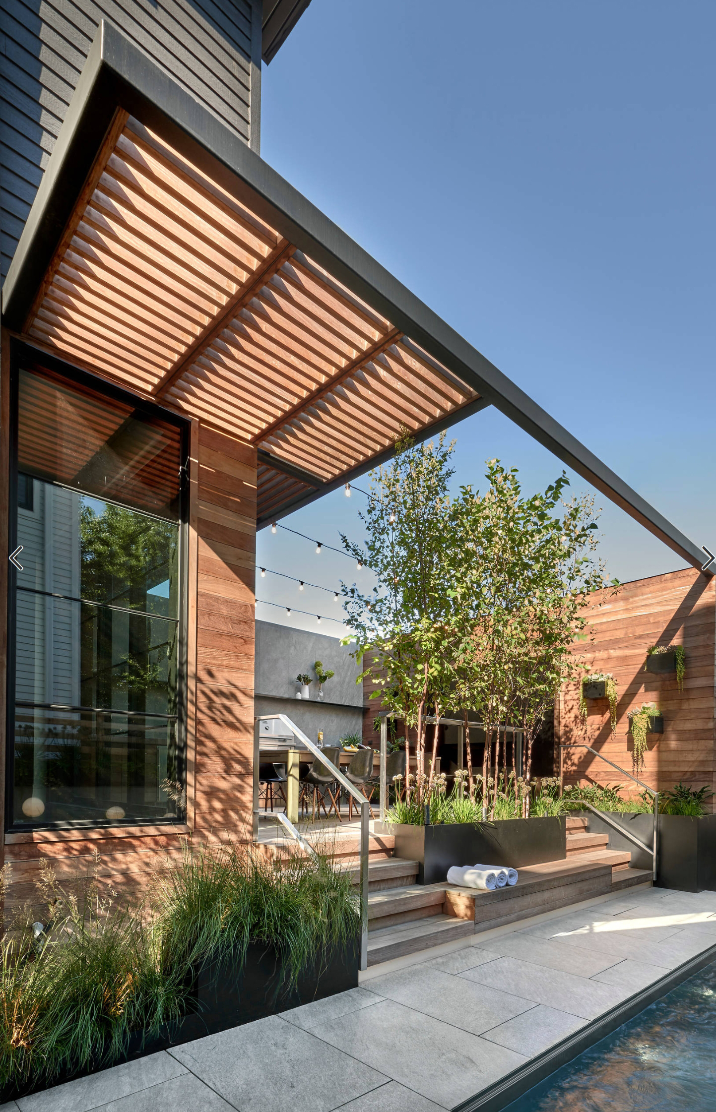 钢结构框架结合防腐木材质的廊架从别墅建筑上"生长"出来,黑色和原木