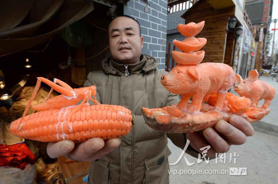 2019年1月5日,郭玉红展示他创作的胡萝卜刻画作品.