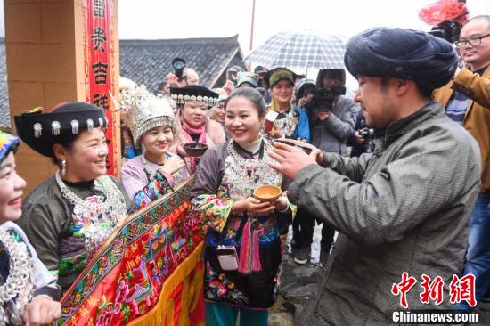 苗族姑娘们摆起了拦门酒迎接迎亲队伍.