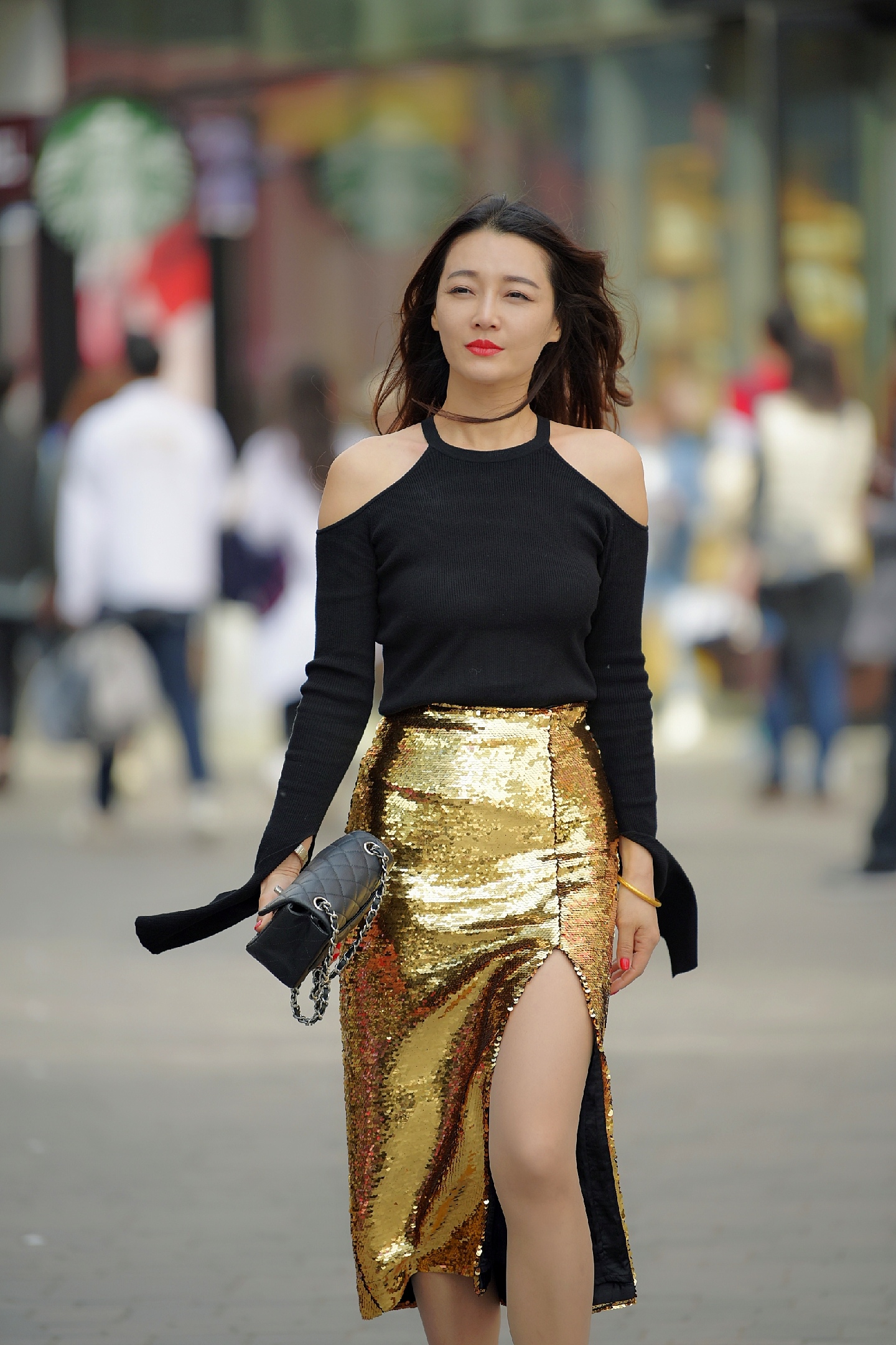 小姐姐穿着一款bling bling的金色长筒裙,裙子侧开衩的设计,美丽时尚