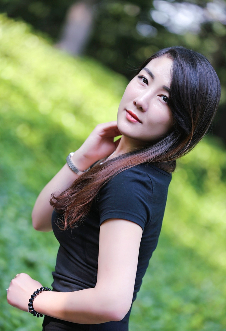 一个在公园阳光美景下的温情长发女子