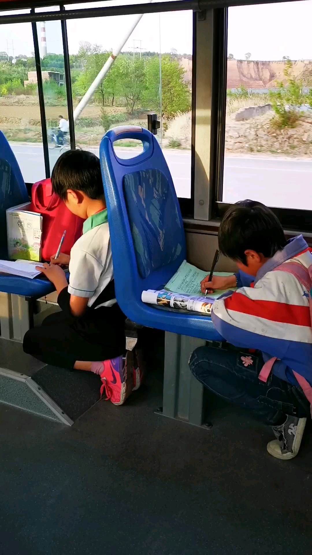 在公交车上做作业的小学生