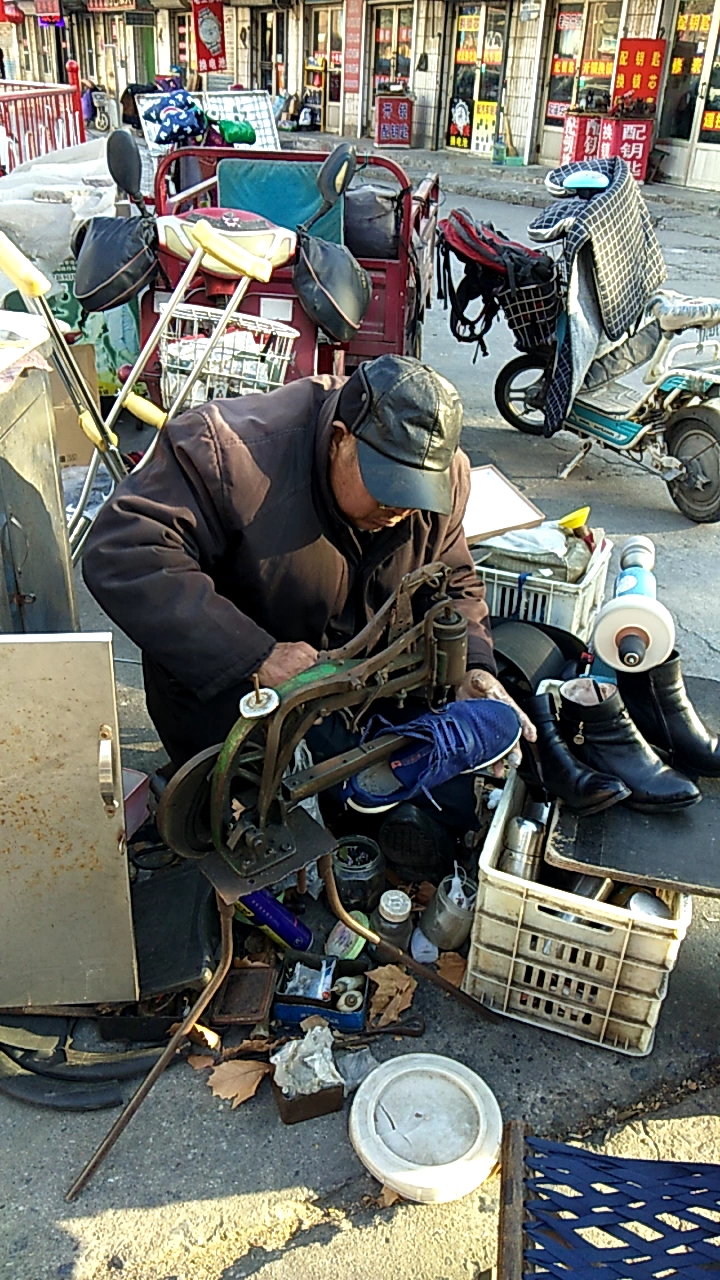 寒风中的街头 一位在修鞋的老人 生活不易,且行且珍惜