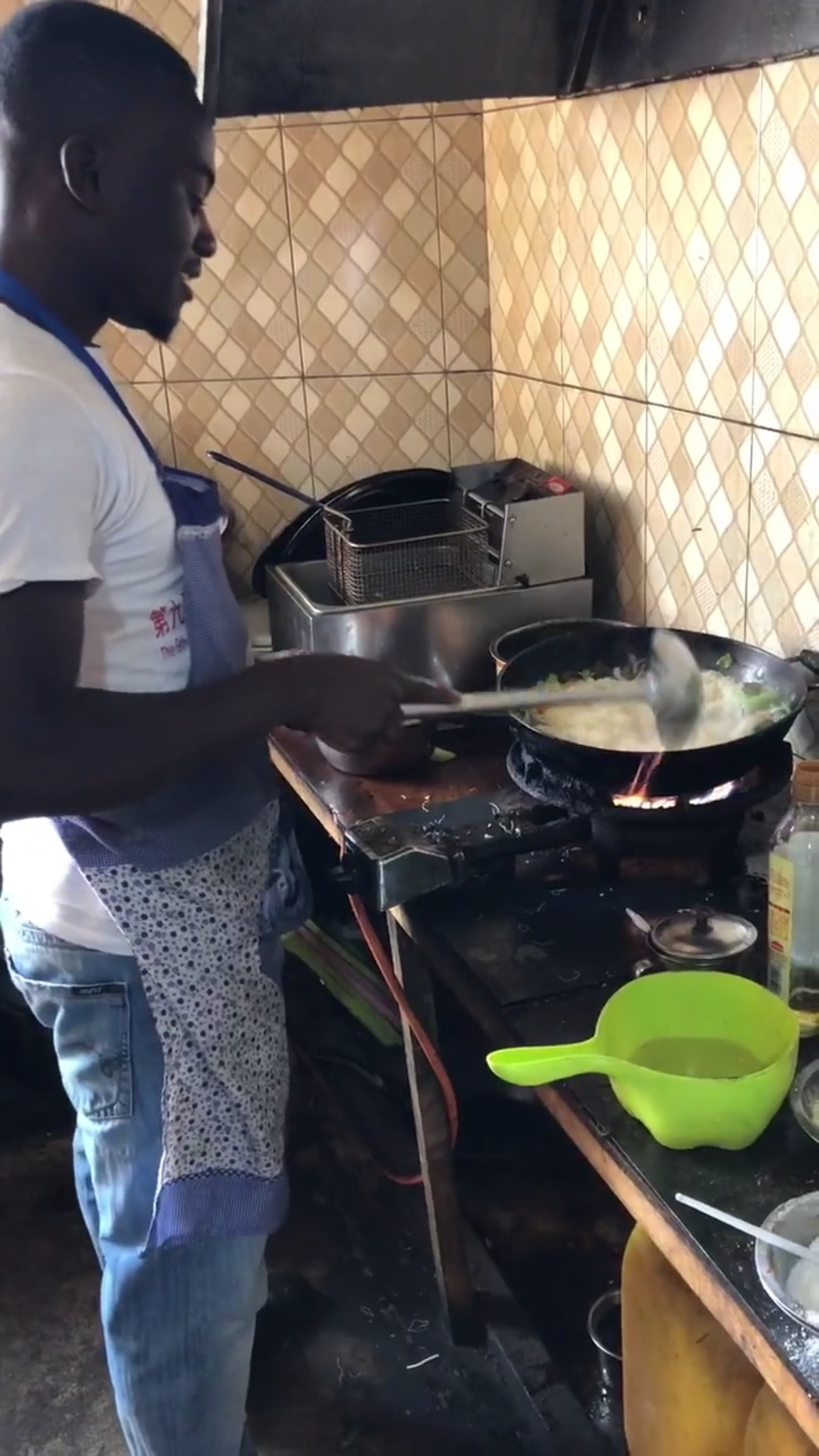 中餐馆里黑人厨师在做炒米粉