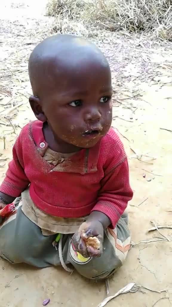 这个非洲小朋友的脸也太脏了吧,在吃东西前怎么不先洗一下呢