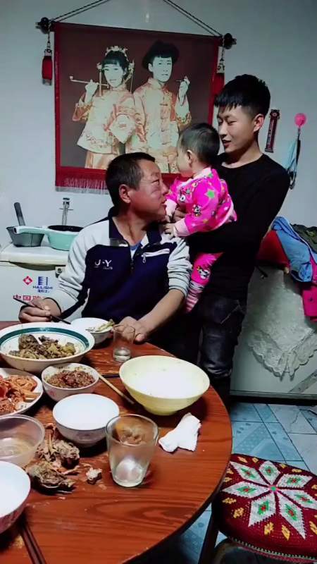 爷爷吃饭呢干吃吃不完了大孙子想让爷爷抱他看给大孙子馋的