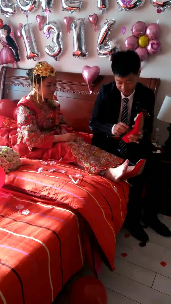 新郎正帮新娘子穿鞋呢,祝福这对新人永远幸福