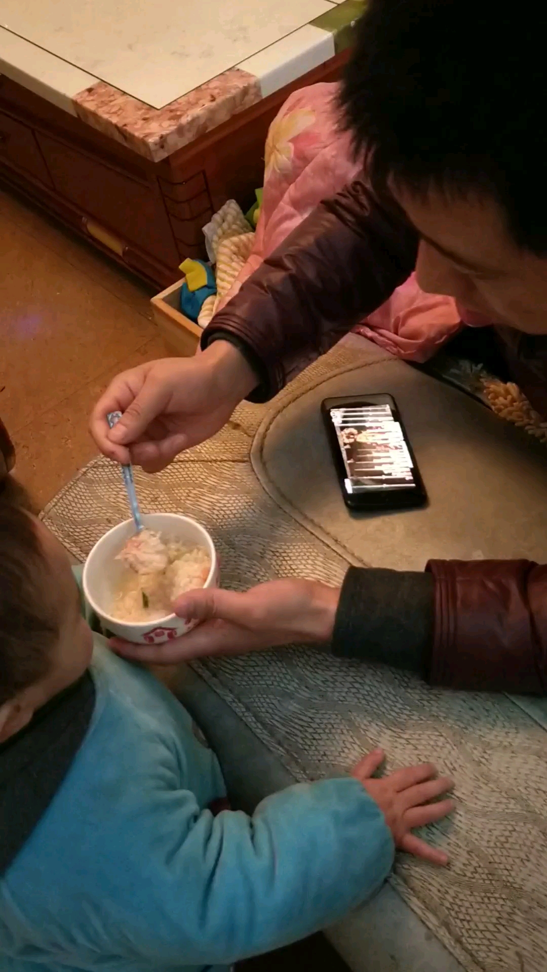 边喂儿子吃饭边看手机电视