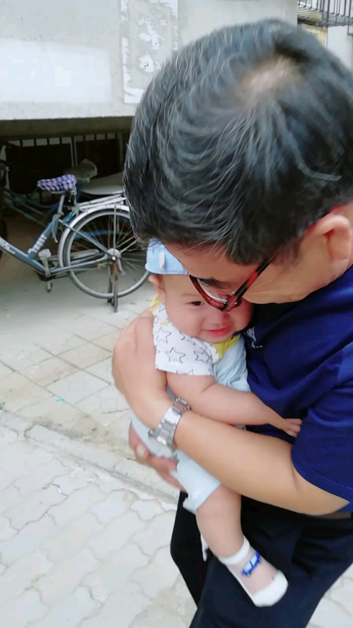 这孩子胆小,揪着爷爷的衣服.