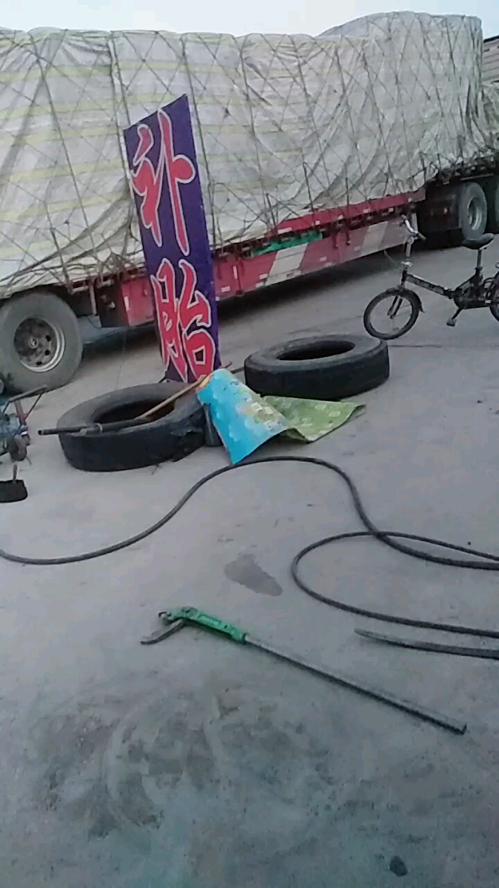 这大车拉重载车爆胎了,在这补胎呢