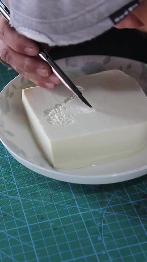 在豆腐上作画也被称为是艺术家男子凭借刀工在豆腐上画财神爷,惟妙惟