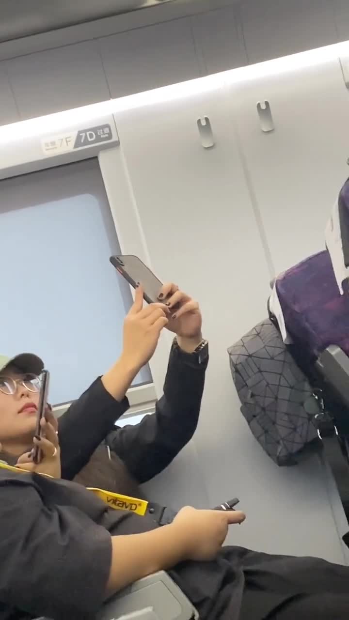 在动车上看到一位美女在自拍,旁边的女生好像在抽电子烟