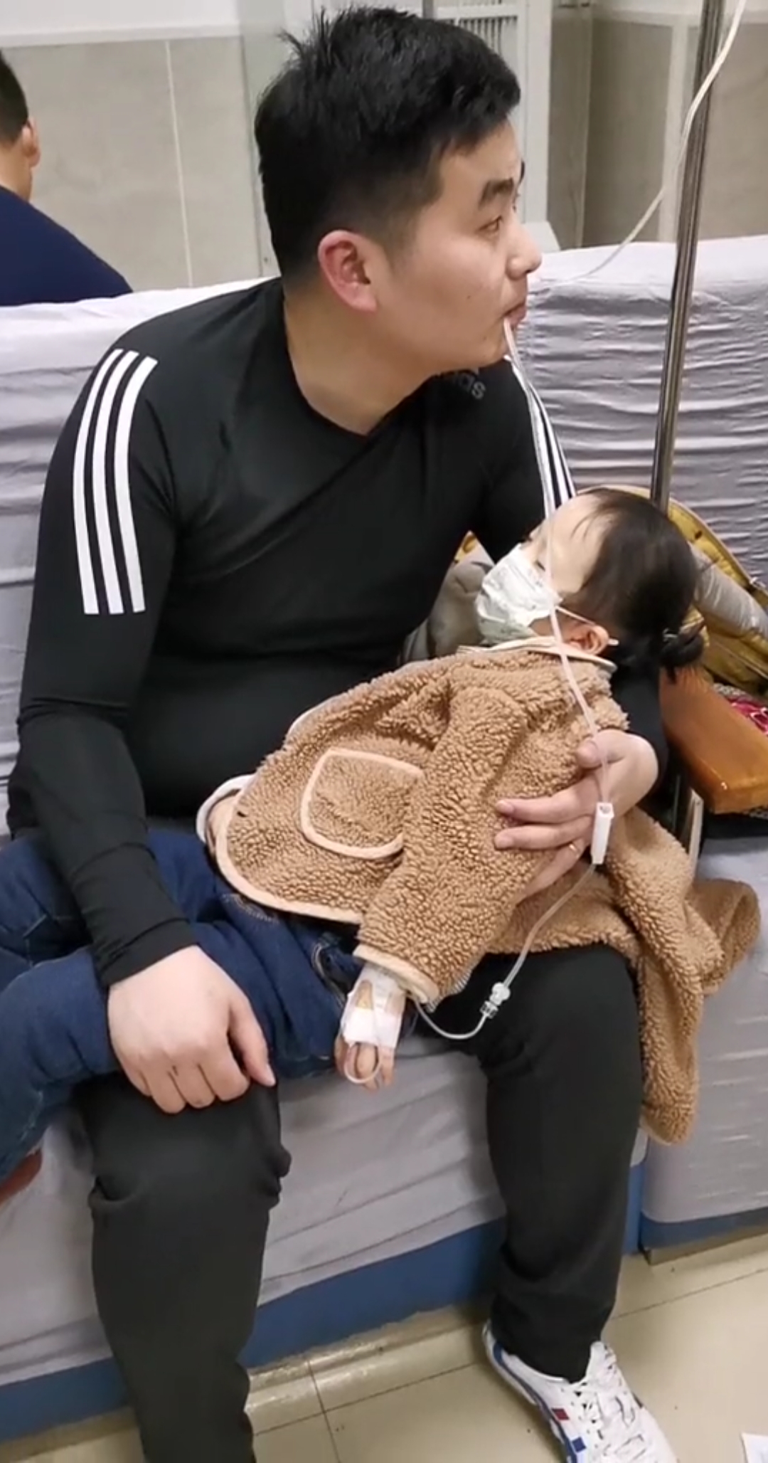 这位伟大的父亲女儿打点滴,为了不让药太凉,选择这样,希望早点好!