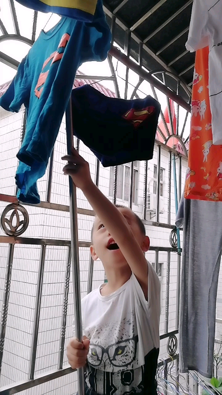 小家伙非要帮忙晒衣服