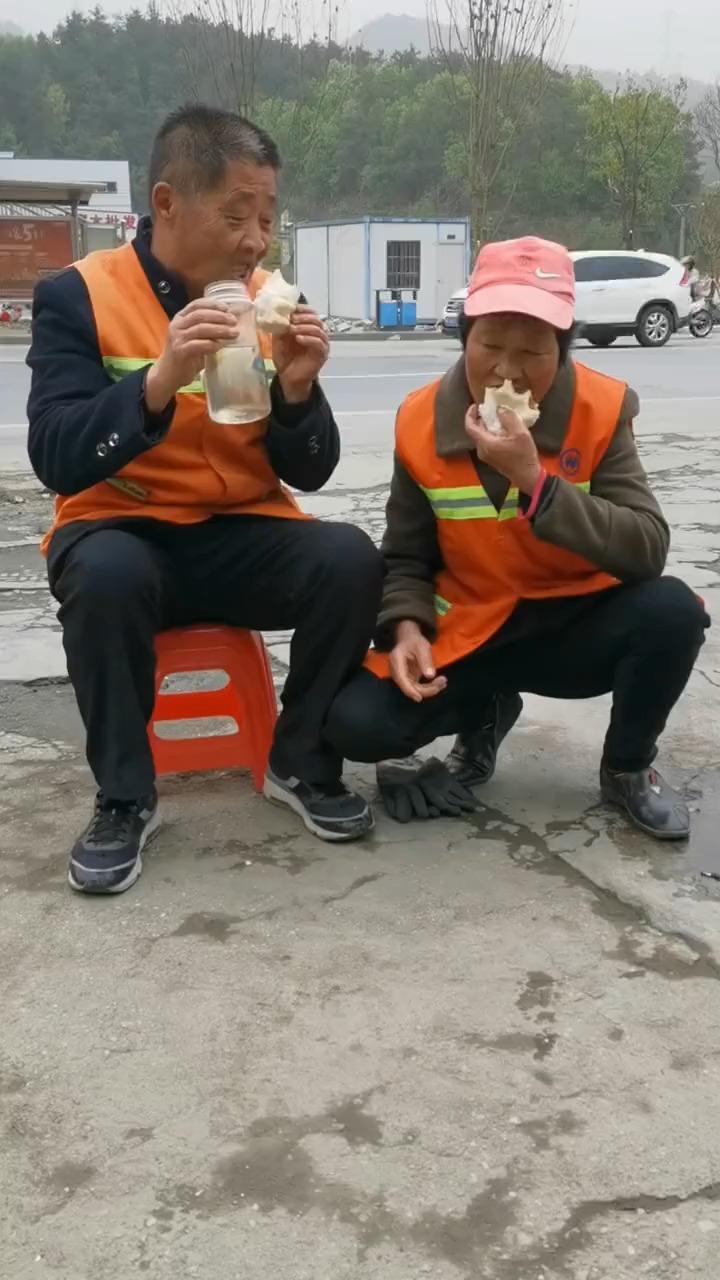 夫妻环卫工蹲地吃馒头时这笑容,感动了你吗?