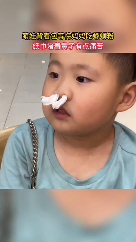 萌娃萌娃背着包等待妈妈吃螺蛳粉纸巾堵着鼻子有点痛苦