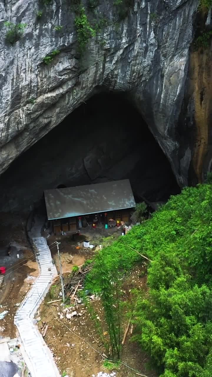 貴州深山裡的山洞人家,房子後面是一個很深的山洞,裡面有暗河,洞口