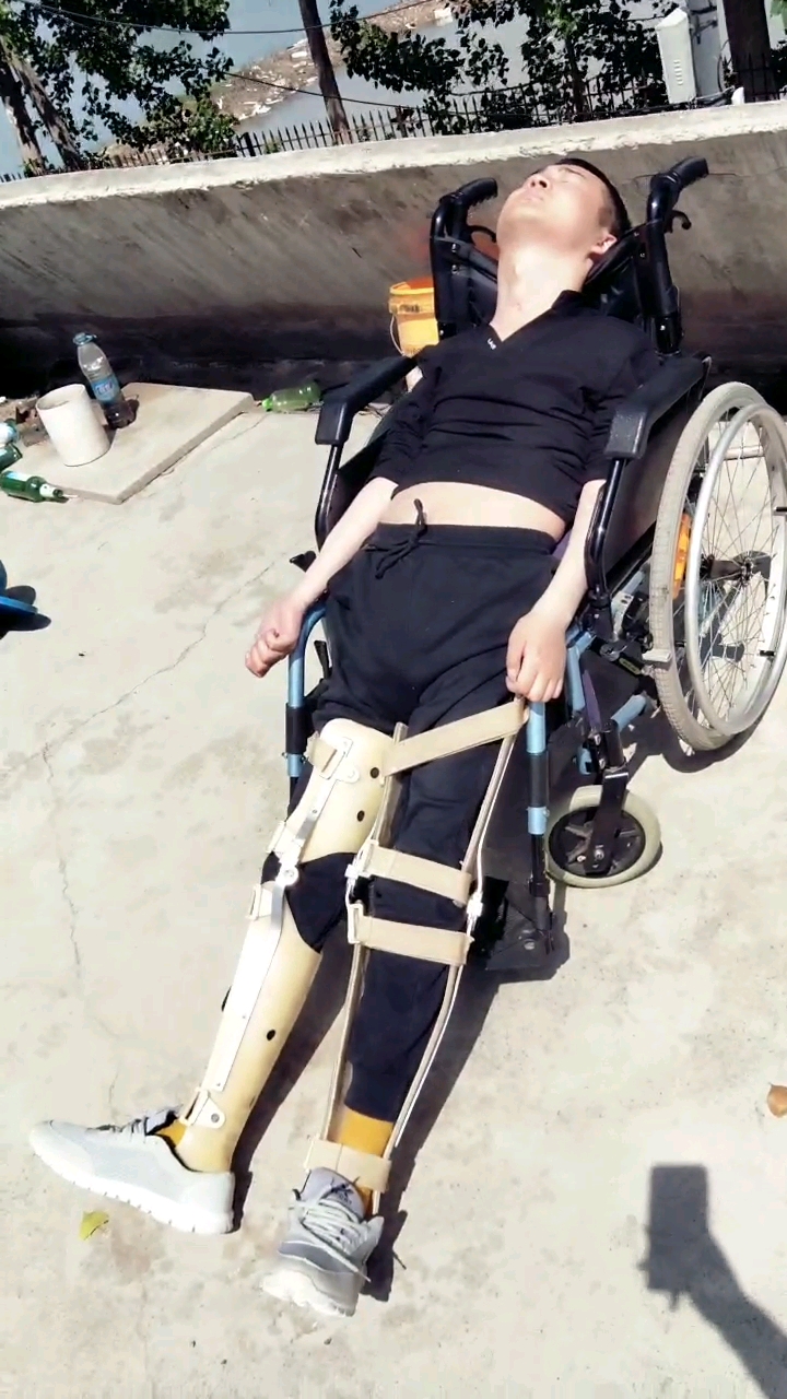 高位截瘫十年多胸部往下都没有知觉躺在轮椅上晒太阳