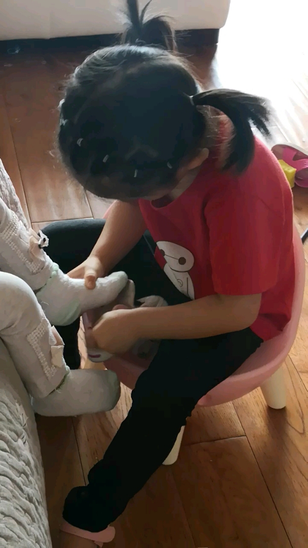 给妹妹穿鞋子,姐姐可以照顾妹妹了