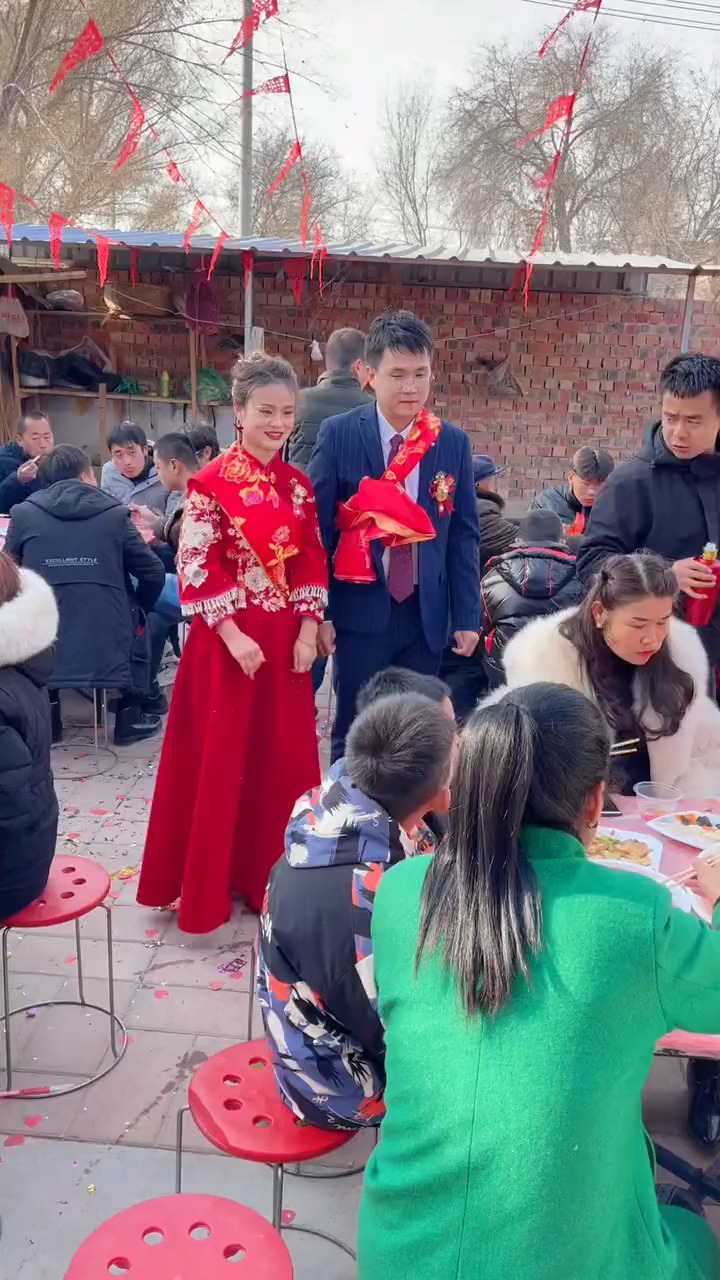 大甘肃农村中的婚礼,新郎拉着新娘的手招待亲朋好友.